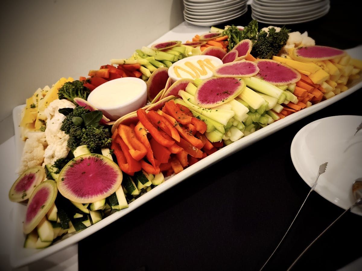 A large white tray filled with vegetables and dip
