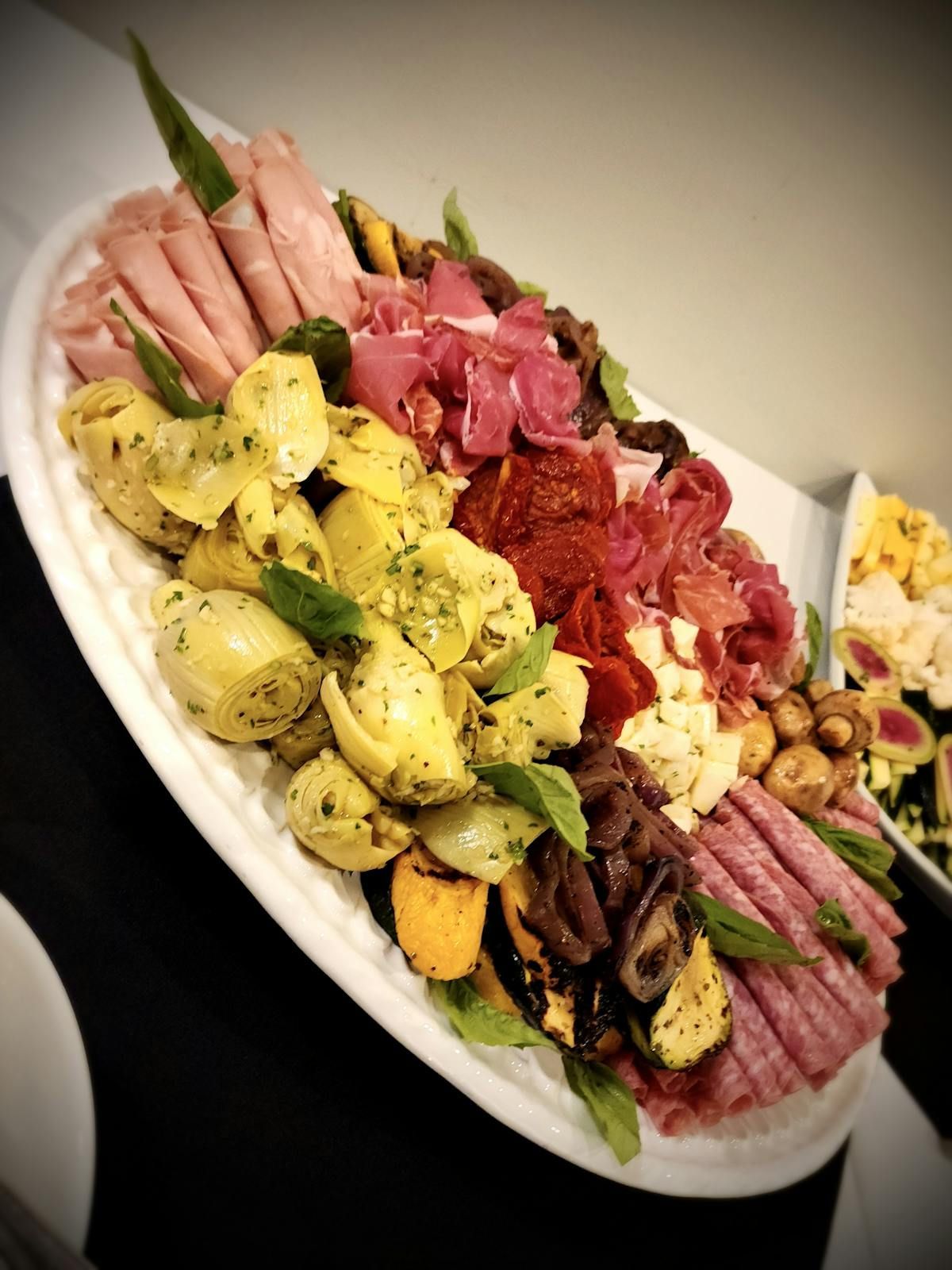A white plate topped with a variety of meats and vegetables.