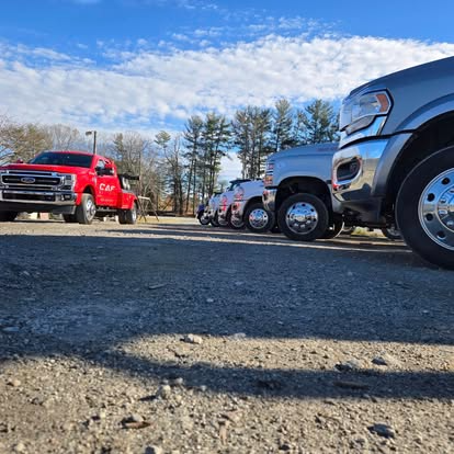 Two tow trucks are parked next to each other in front of a building.