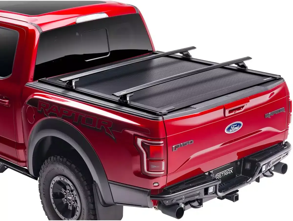 Red Ford Raptor truck with black tonneau cover and roof rack.
