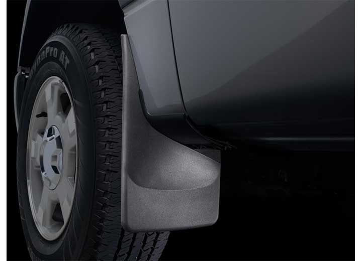 Black mud flap attached to a dark-colored vehicle's rear wheel, protecting from debris.