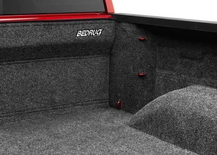 Dark gray BedRug truck bed liner installed in a red truck bed.