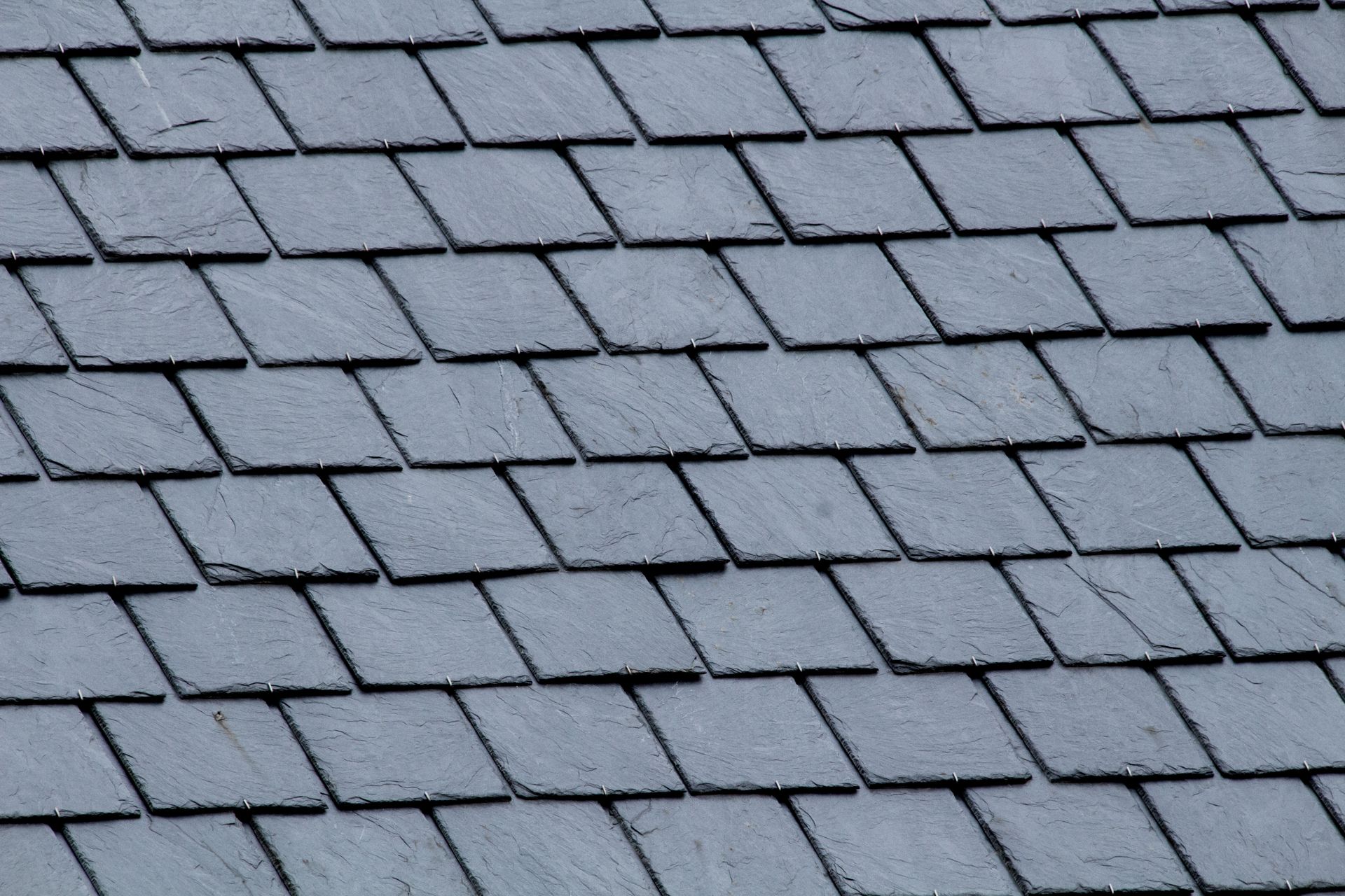 Gray roof shingles arranged in neat overlapping rows