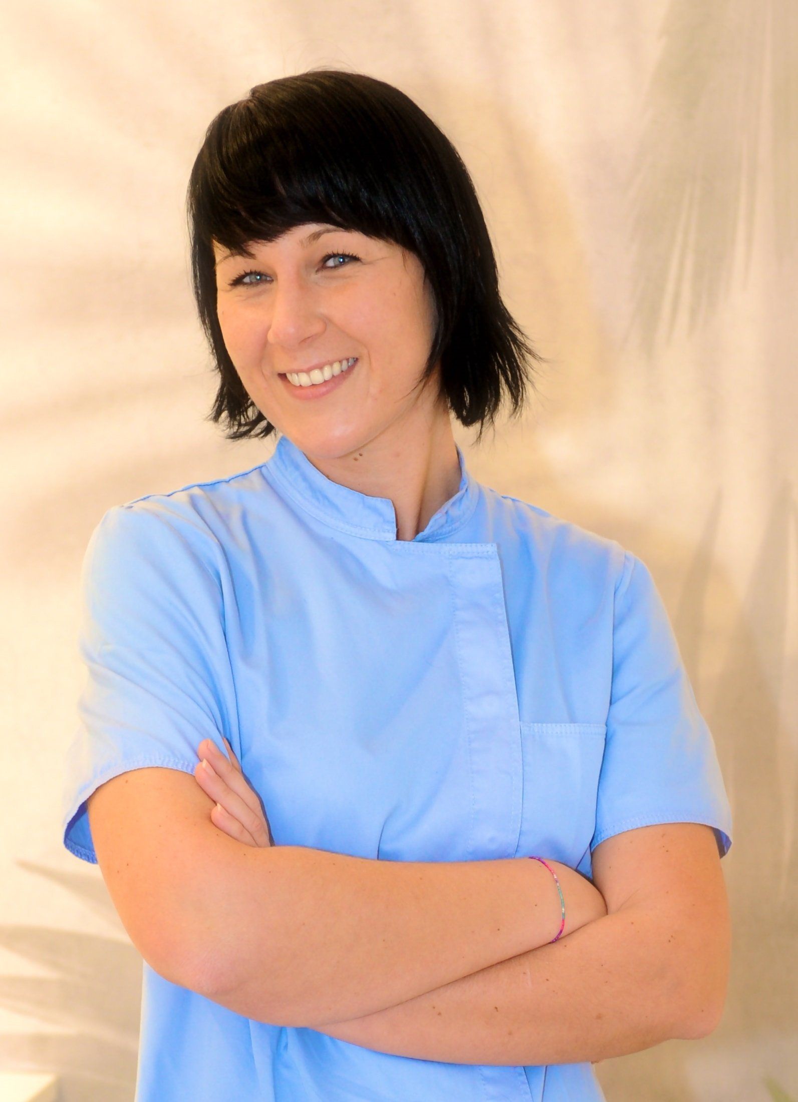 Una donna con una camicia blu e le braccia incrociate