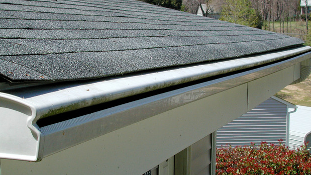 A close up of a gutter on a roof of a house.