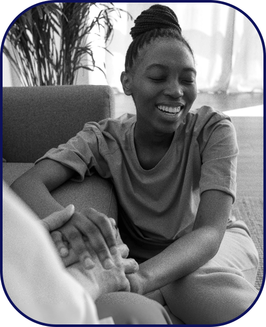 A therapist holding her patient's hand as they smile
