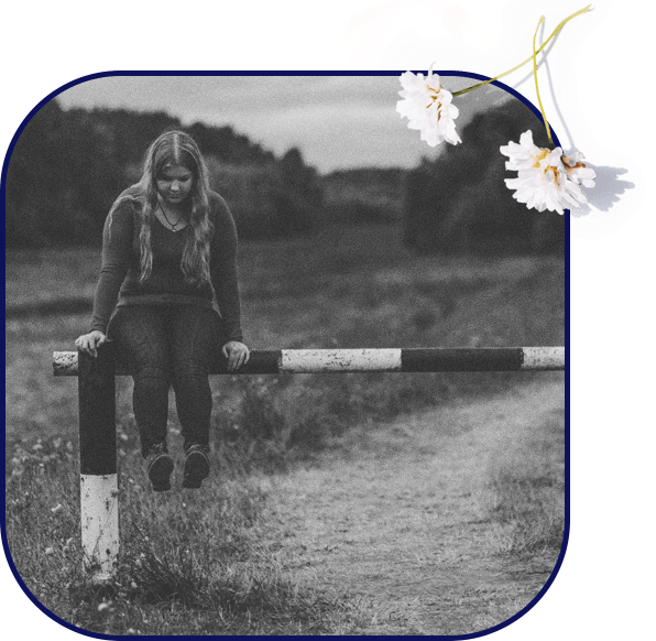 A young woman sitting on a barrier reflecting