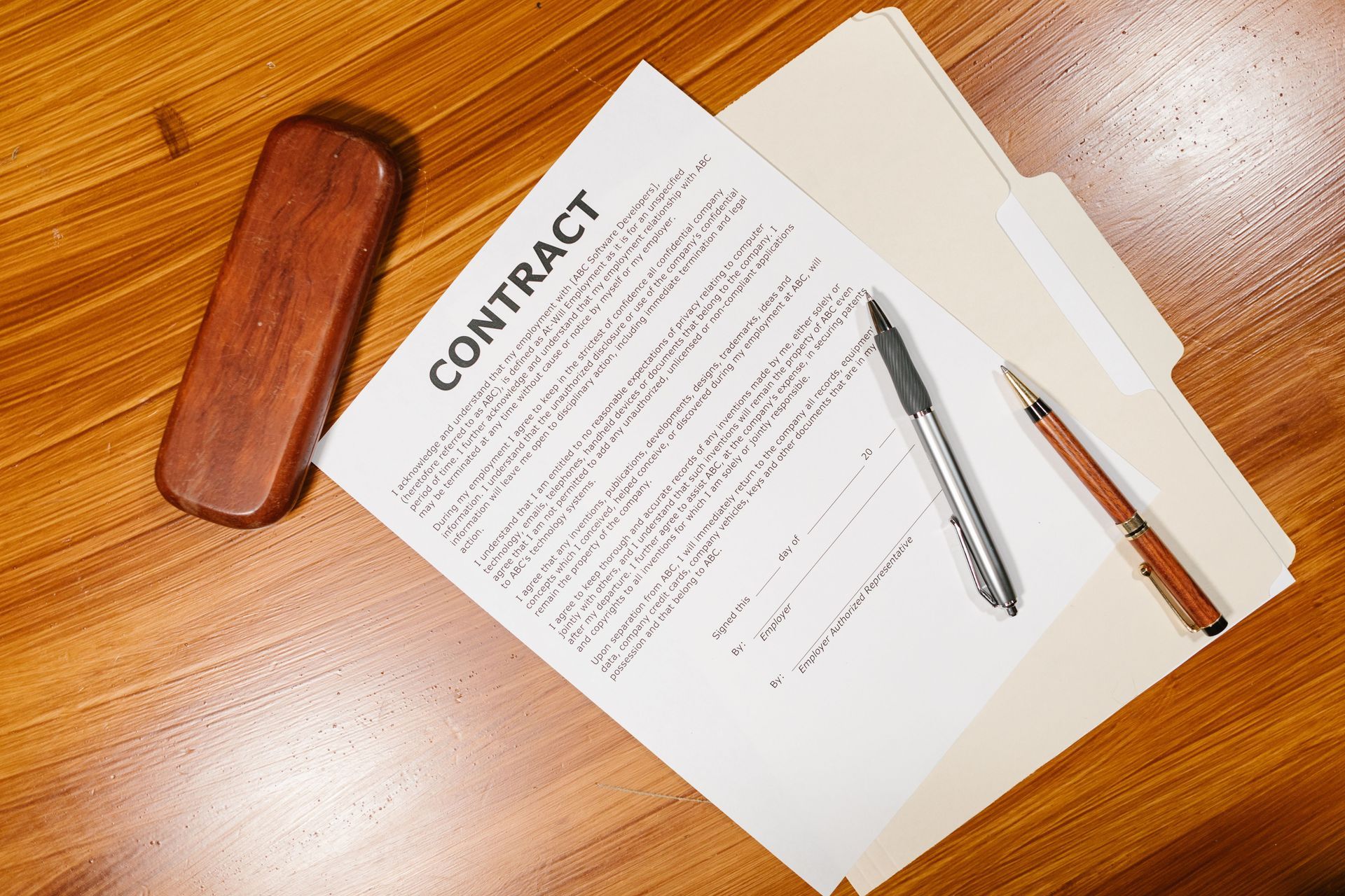 Contract papers with pen and glasses on a wooden desk