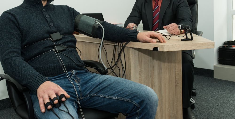 Person wearing a polygraph during a polygraph test at a desk