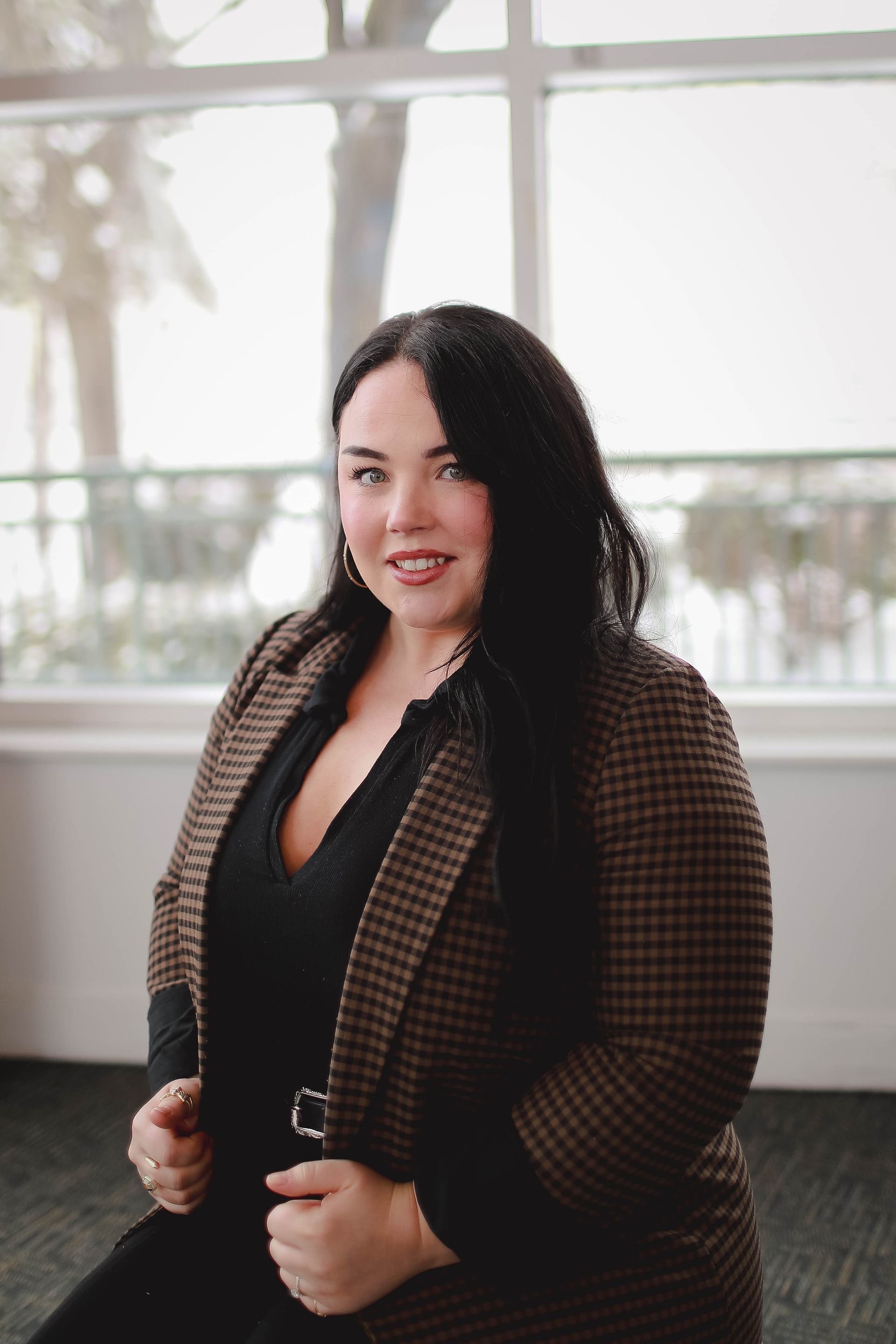 A woman in a green shirt and necklace is smiling for the camera.