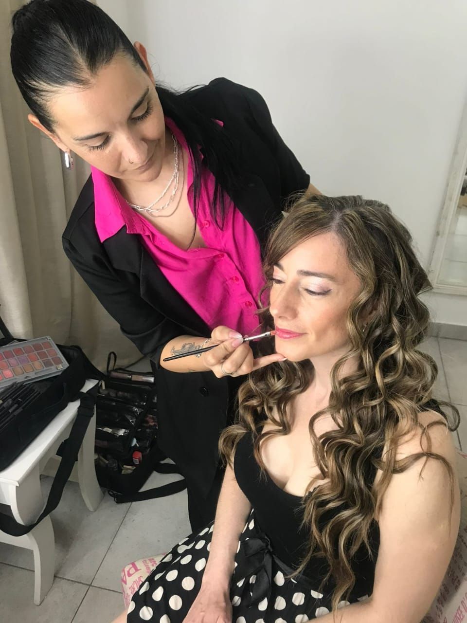 Mujer con cabello castaño y rizado, con tocado dorado y maquillaje.