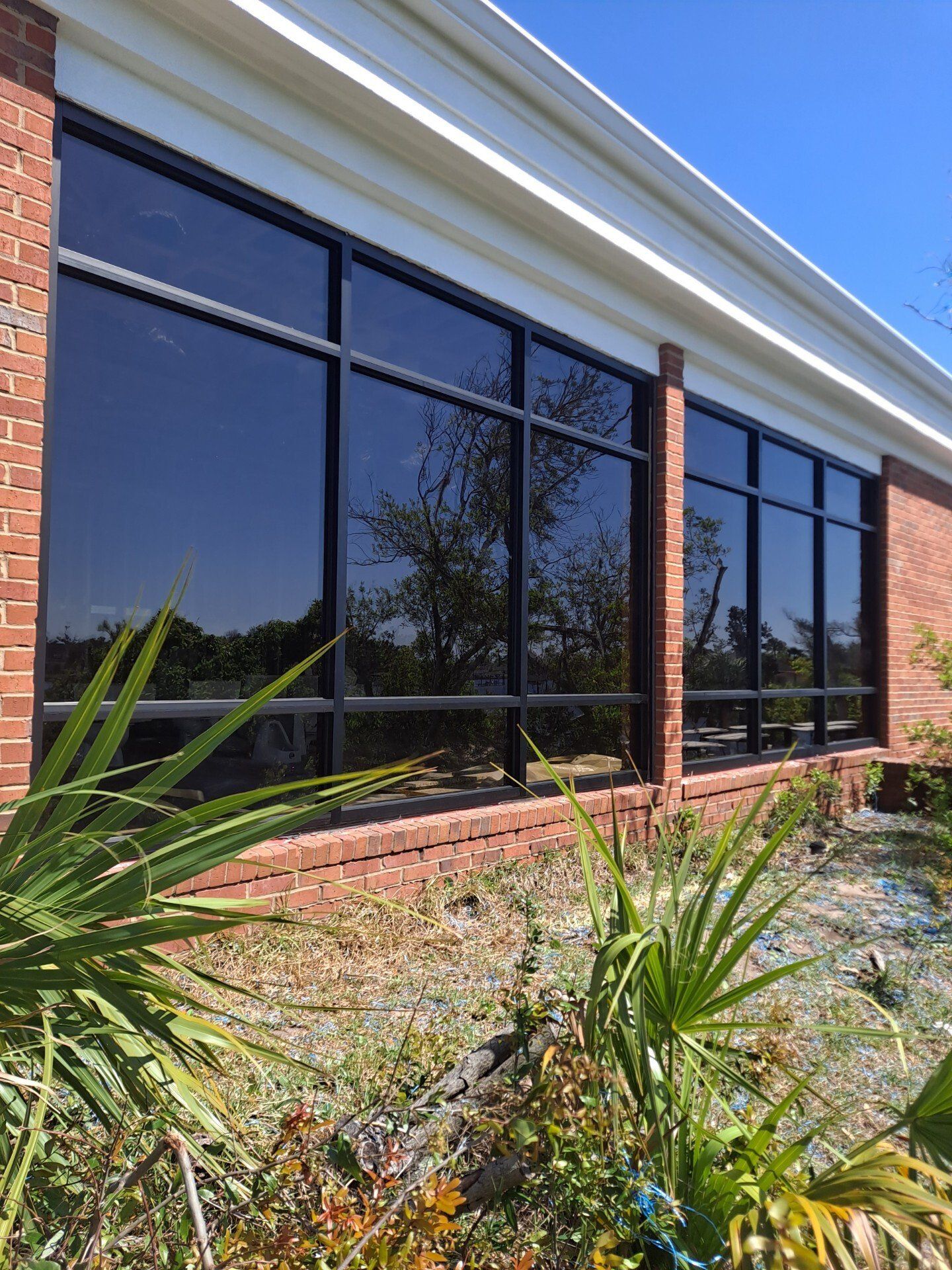 Replacement Glass — Worker Installing a Glass Window in Panama City Beach, FL