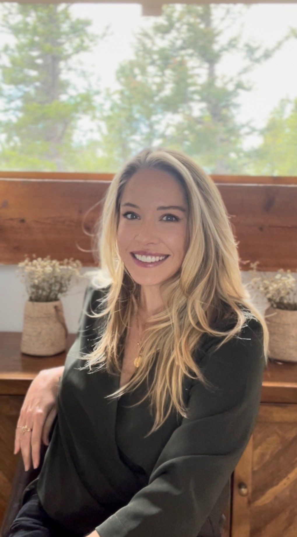 Jen Taylor Therapy — Jen Taylor in Boulder CO a woman in a black jacket is sitting in front of a window .