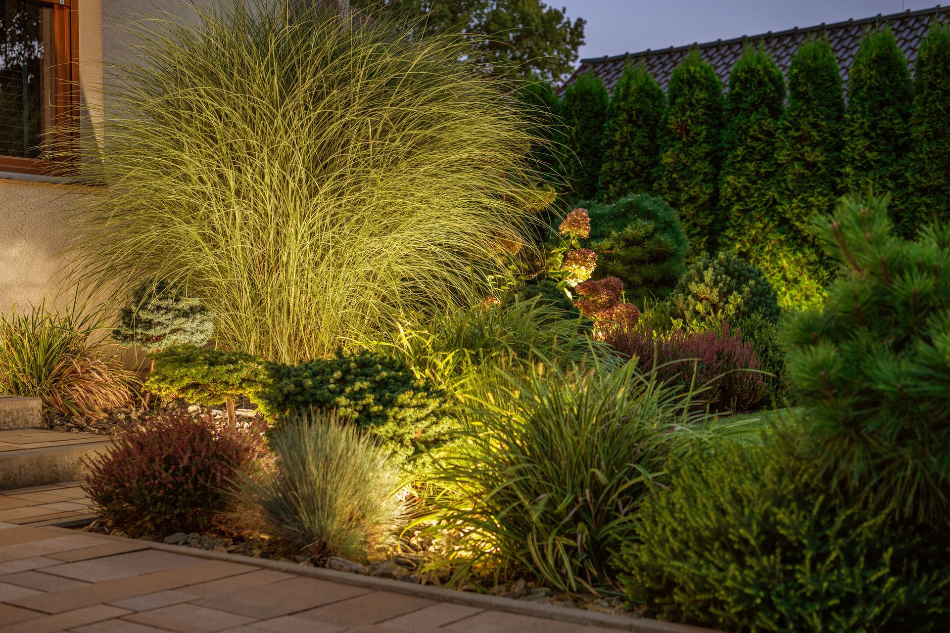A row of solar powered lights in a garden at night.