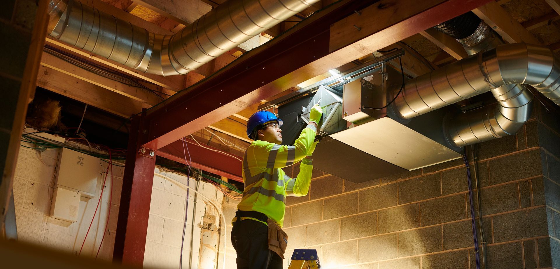 HVAC technician adjusting ductwork and airflow to perform air balancing in a Houston home.