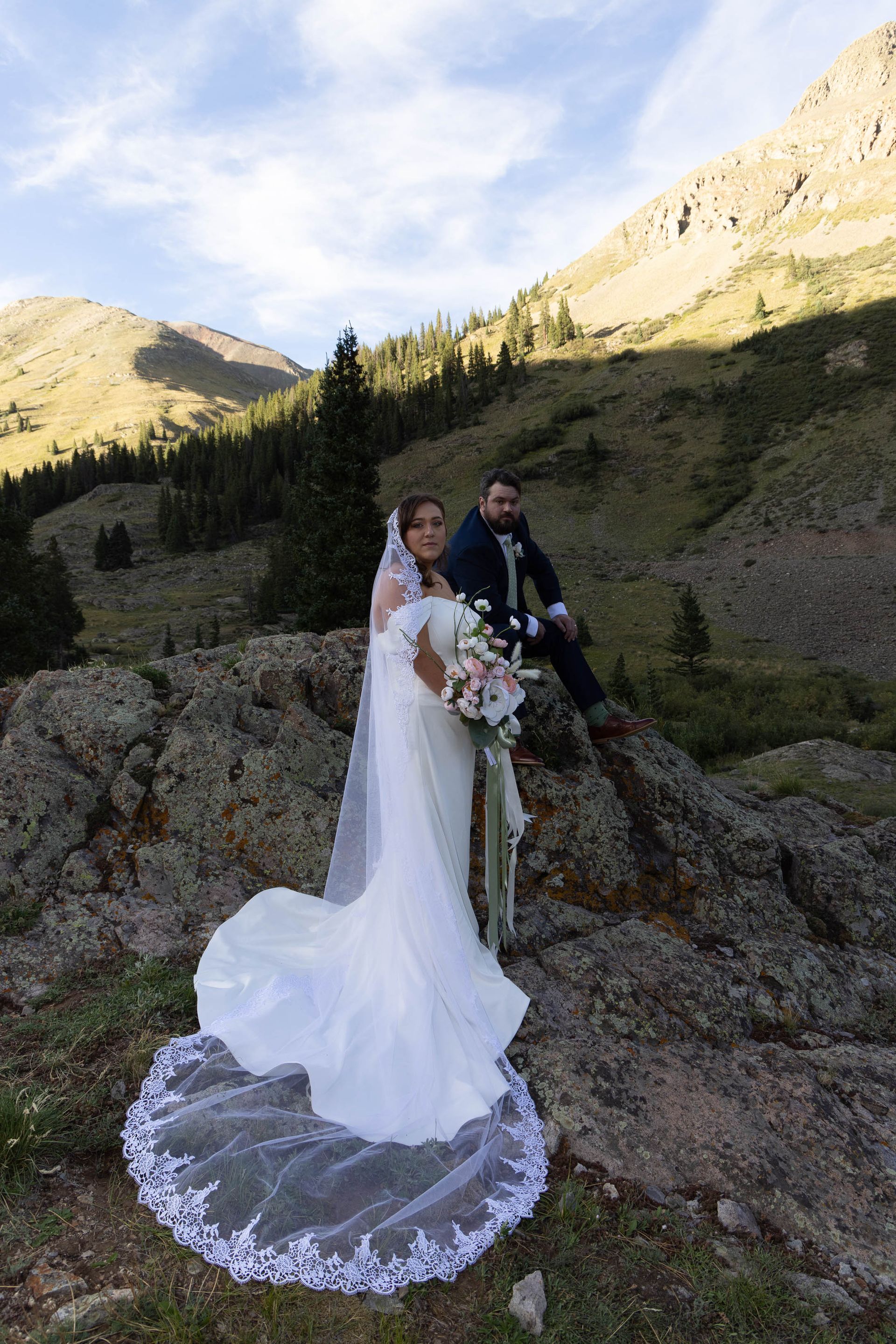 Couple kissing in warm sunlight during an outdoor wedding ceremony