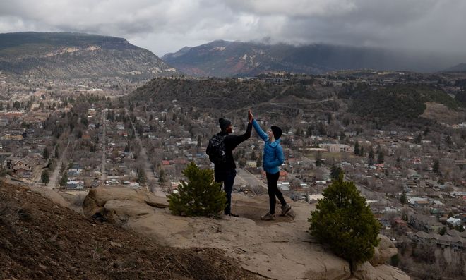 Couple celebrating on a hilltop overlooking Durango, Colorado, photographed by Aelpha Collective