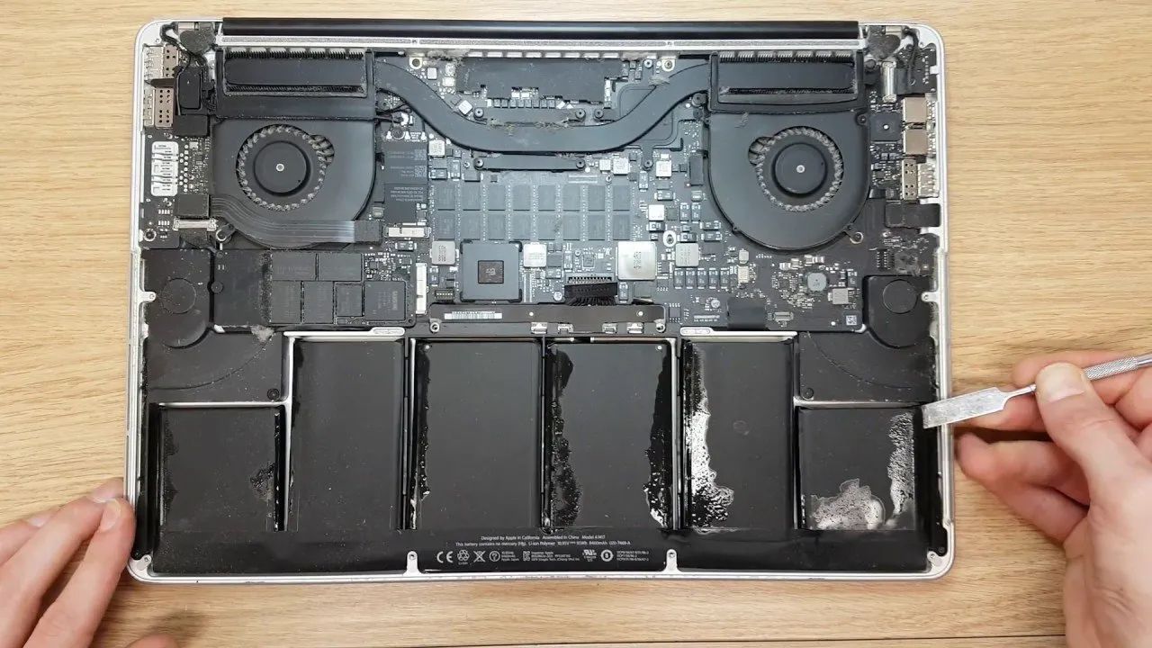 A Person Is Opening ALaptop With A Screwdriver