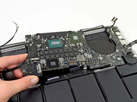 A Person Is Holding The Motherboard Of A Laptop Computer A Person Is Holding The Motherboard Of A Laptop Computer