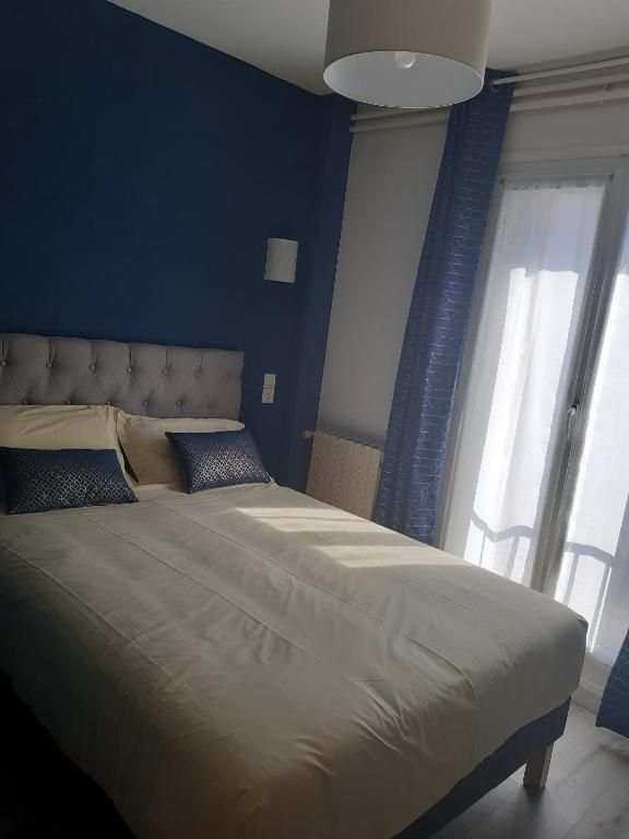 Une chambre avec un lit king size et des murs bleus
