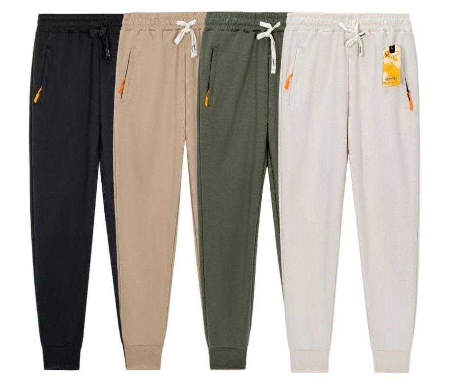 Quattro paia di pantaloni da jogging con coulisse nei colori nero, beige, verde oliva e grigio chiaro su sfondo bianco.