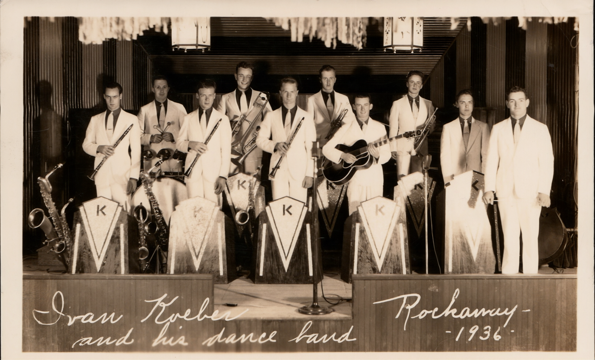 Lineup of men in suits holding instruments on a stage