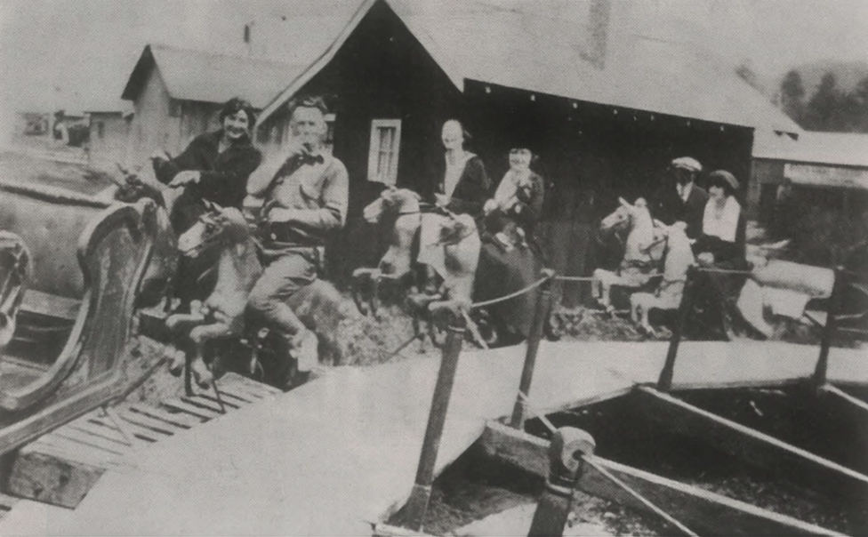 Vintage black-and-white photo of people on a merry-go-round