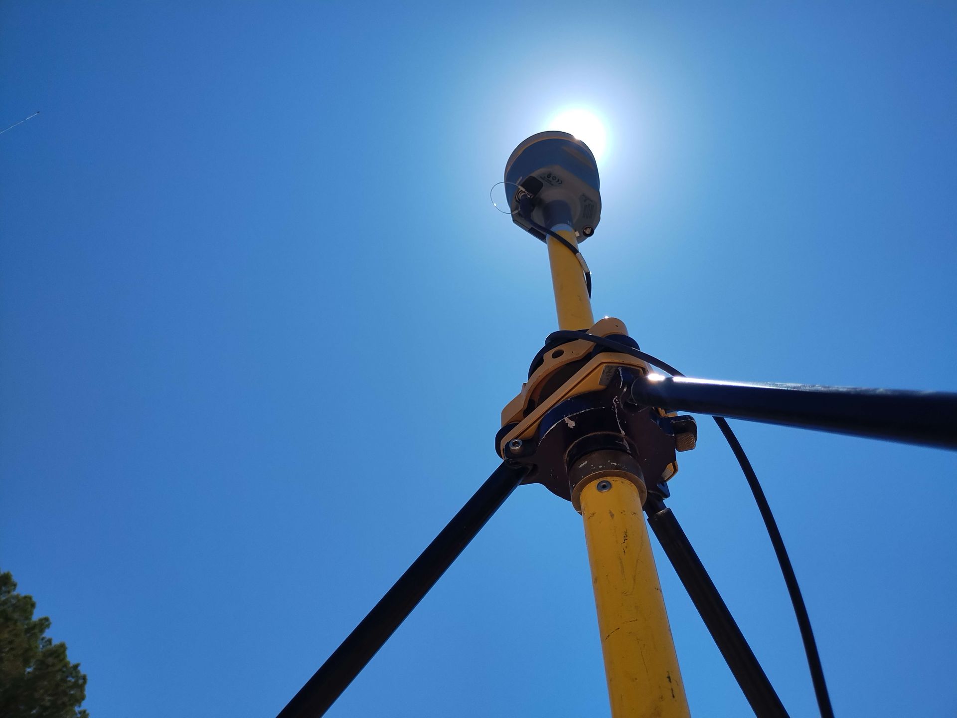 The sun is shining brightly on a yellow pole