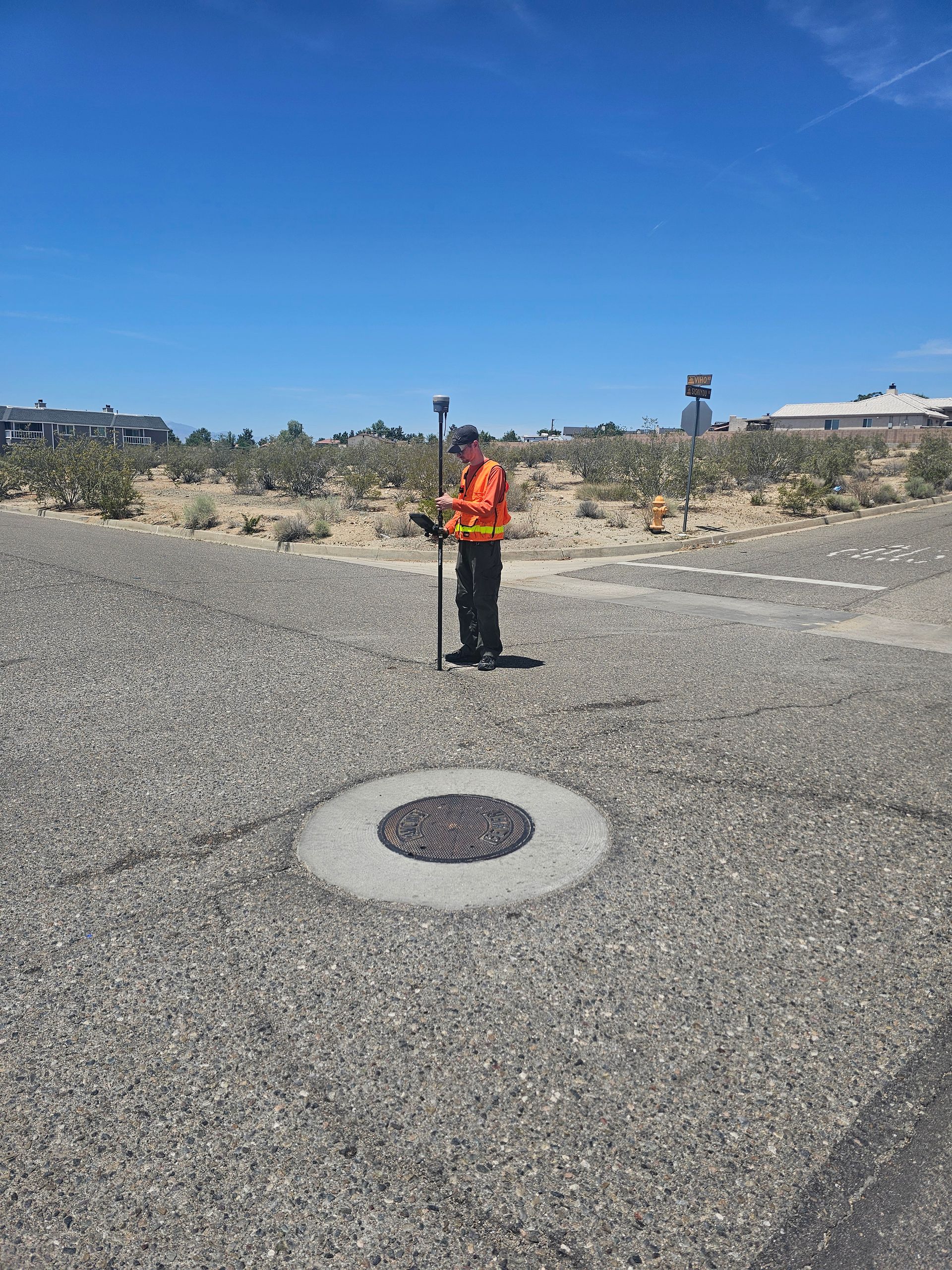 A man is standing in the middle of a gravel road.