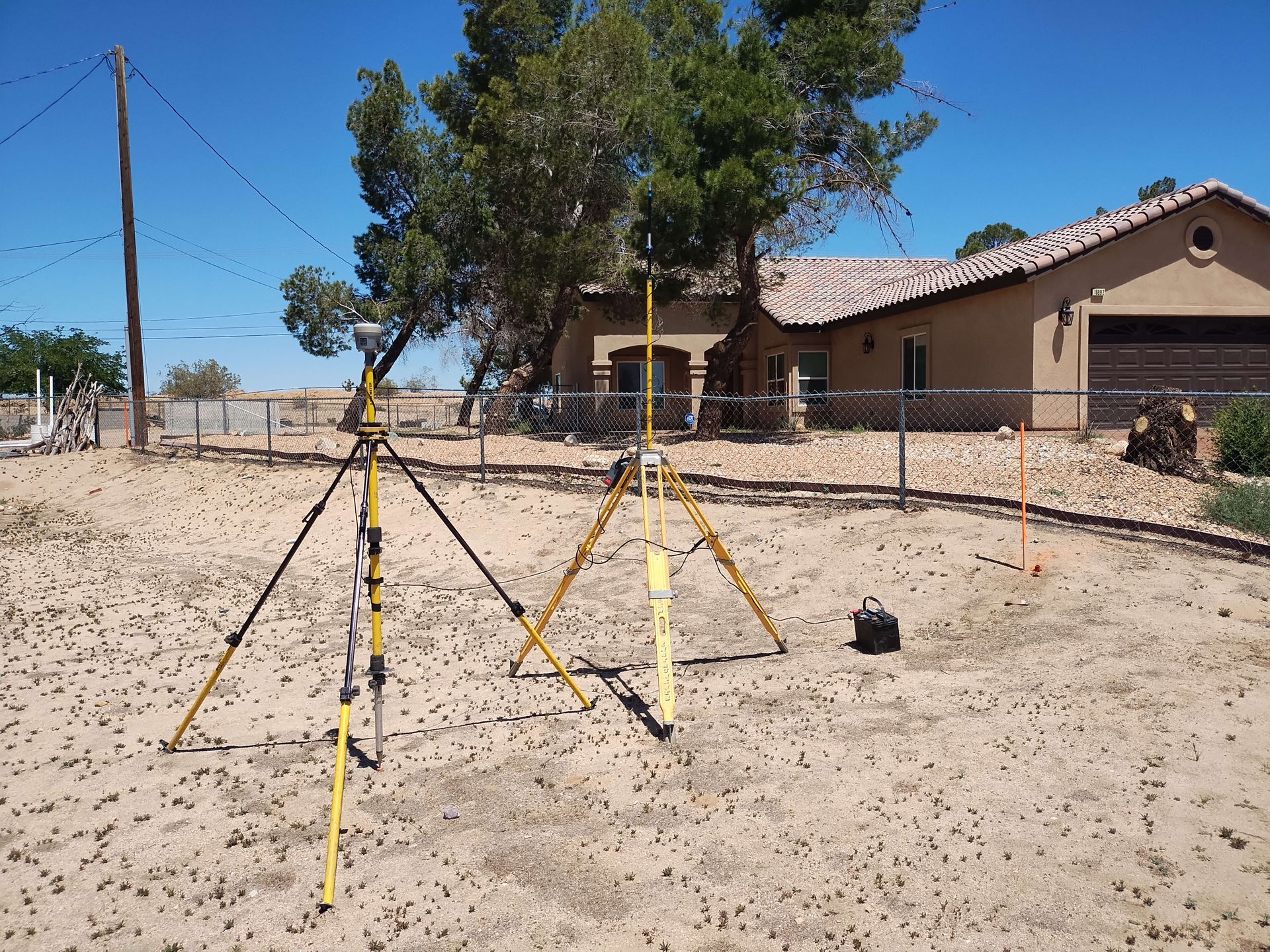 A tripod is sitting in the dirt in front of a house
