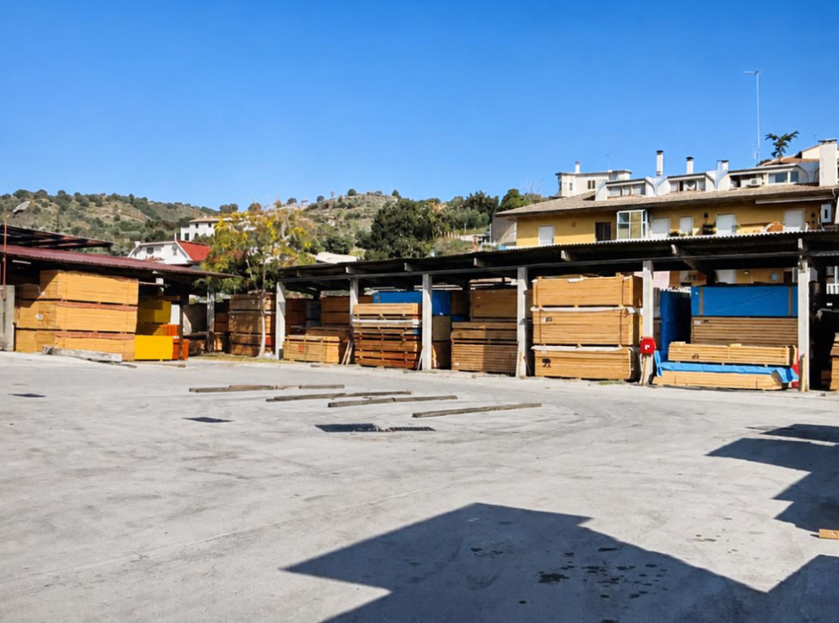 Bancarelle vuote in un mercato all’aperto, sotto un cielo azzurro terso, con edifici e colline sullo sfondo
