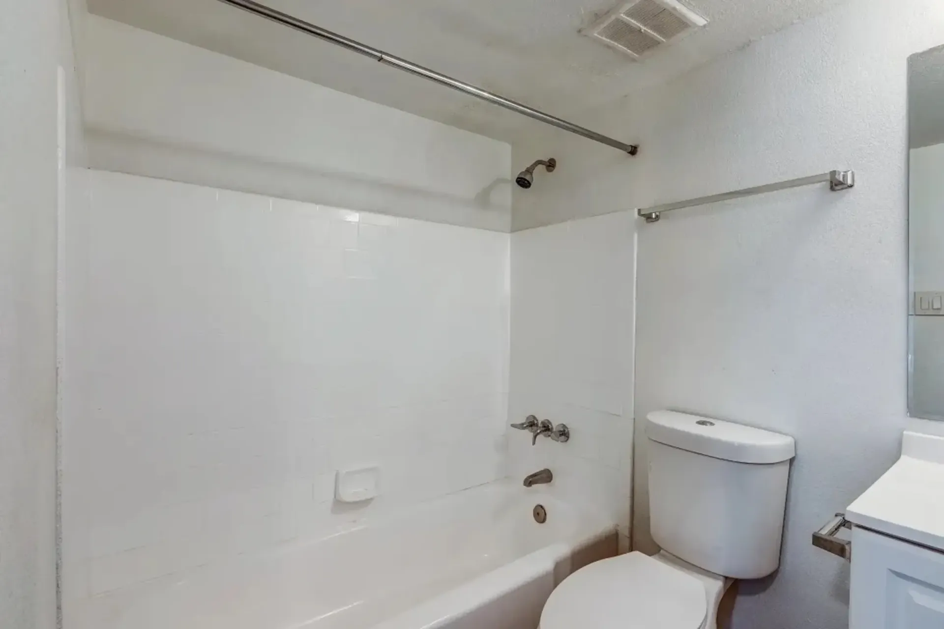 a bathroom with a toilet a bathtub and a mirror