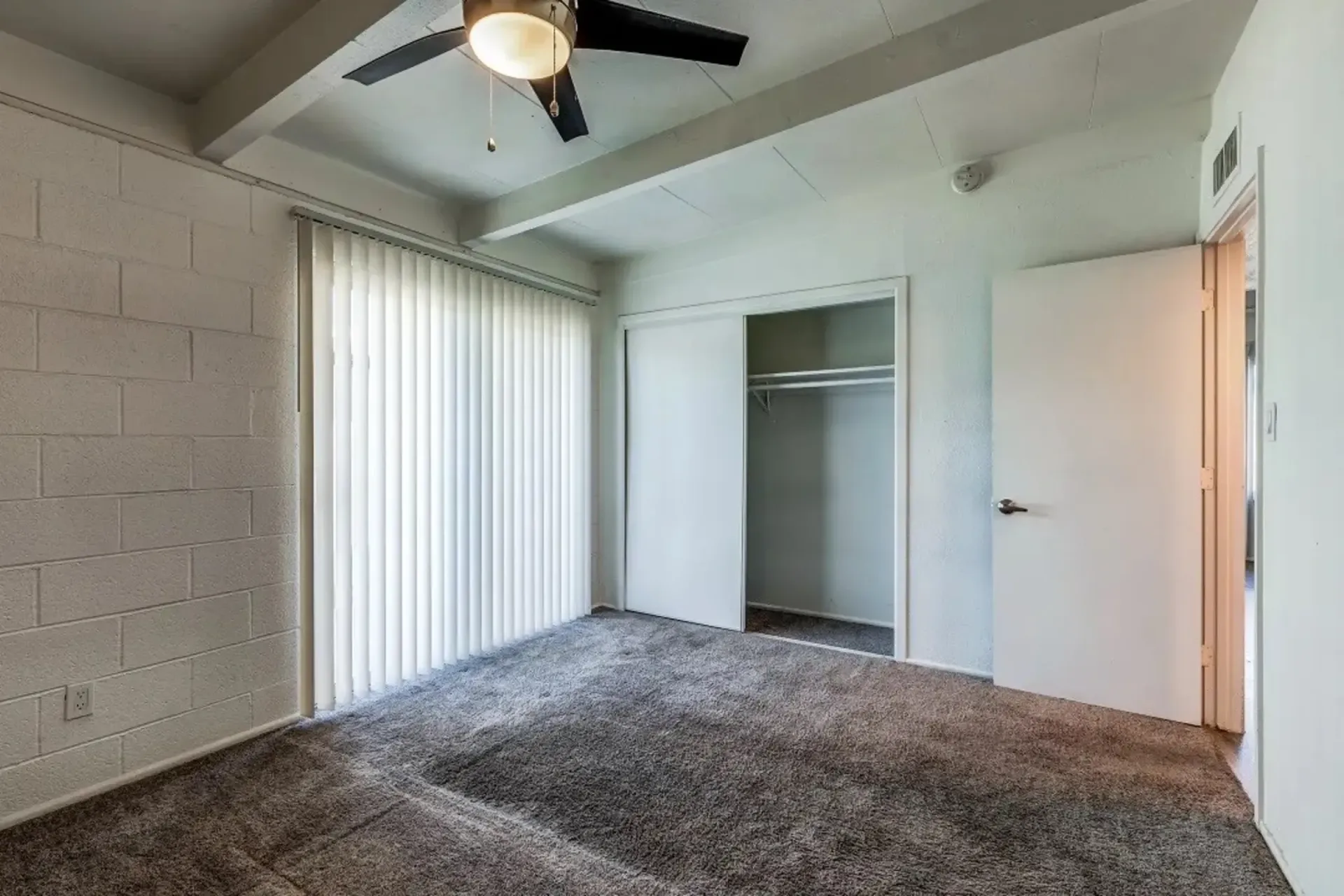 a bedroom with a ceiling fan and a closet