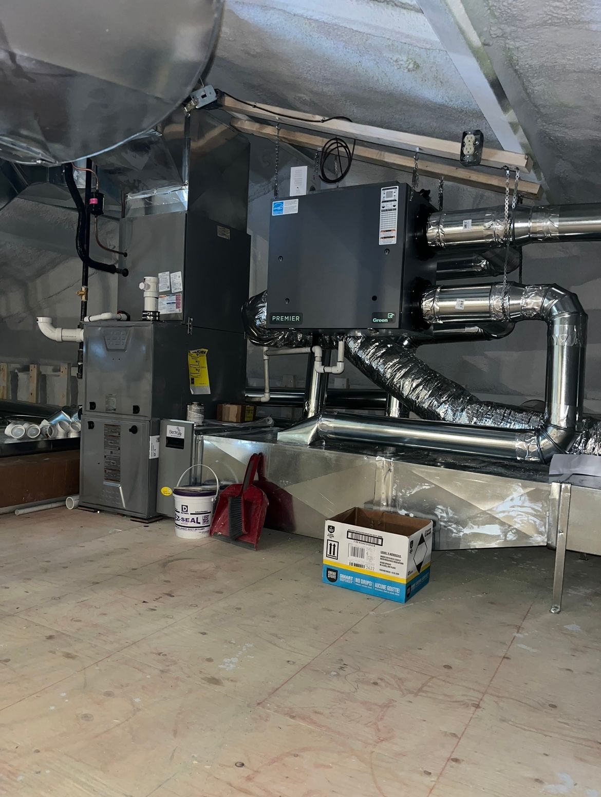 A room with a lot of pipes and a box on the floor.