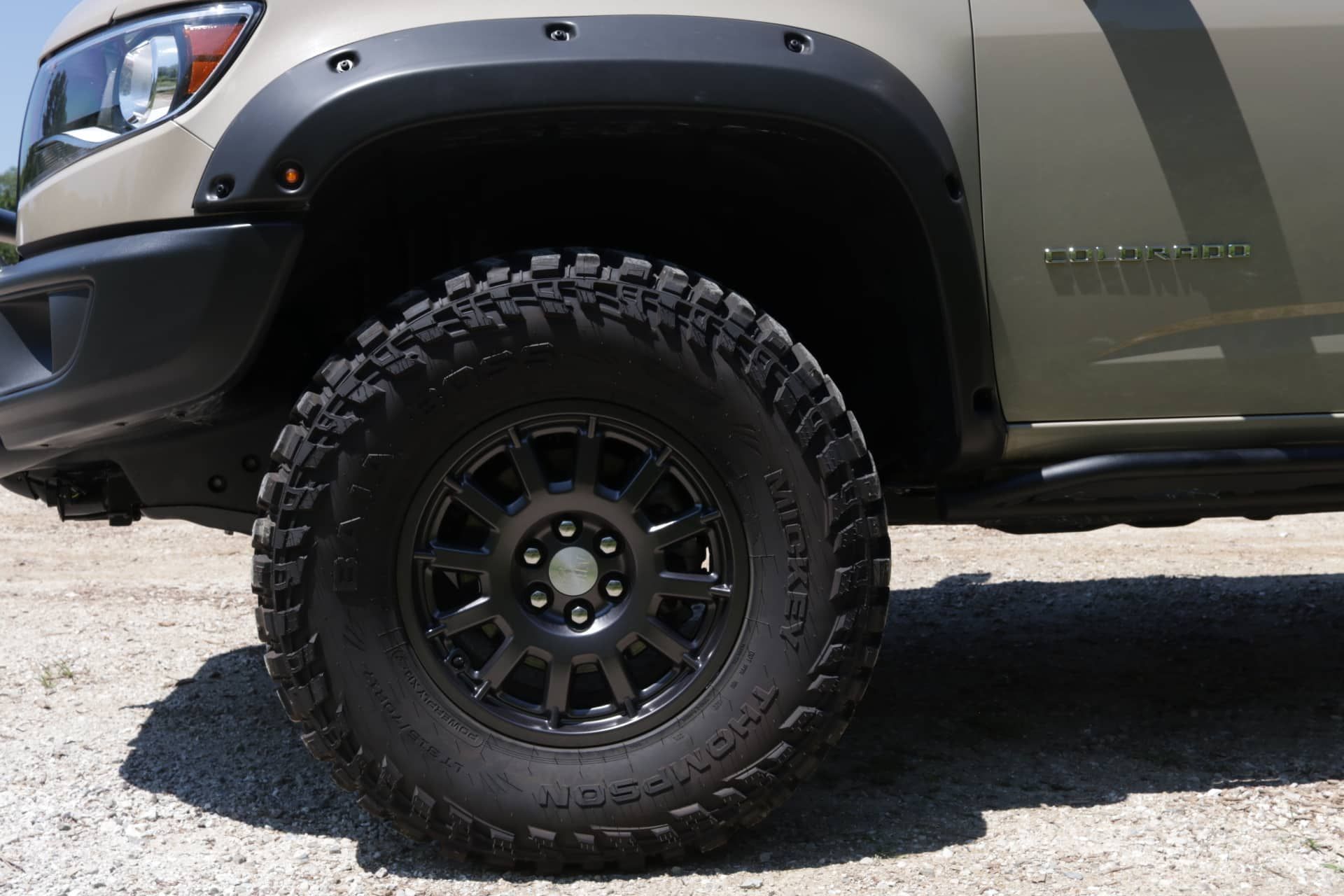 Black off-road tire on a truck with black fender flares.