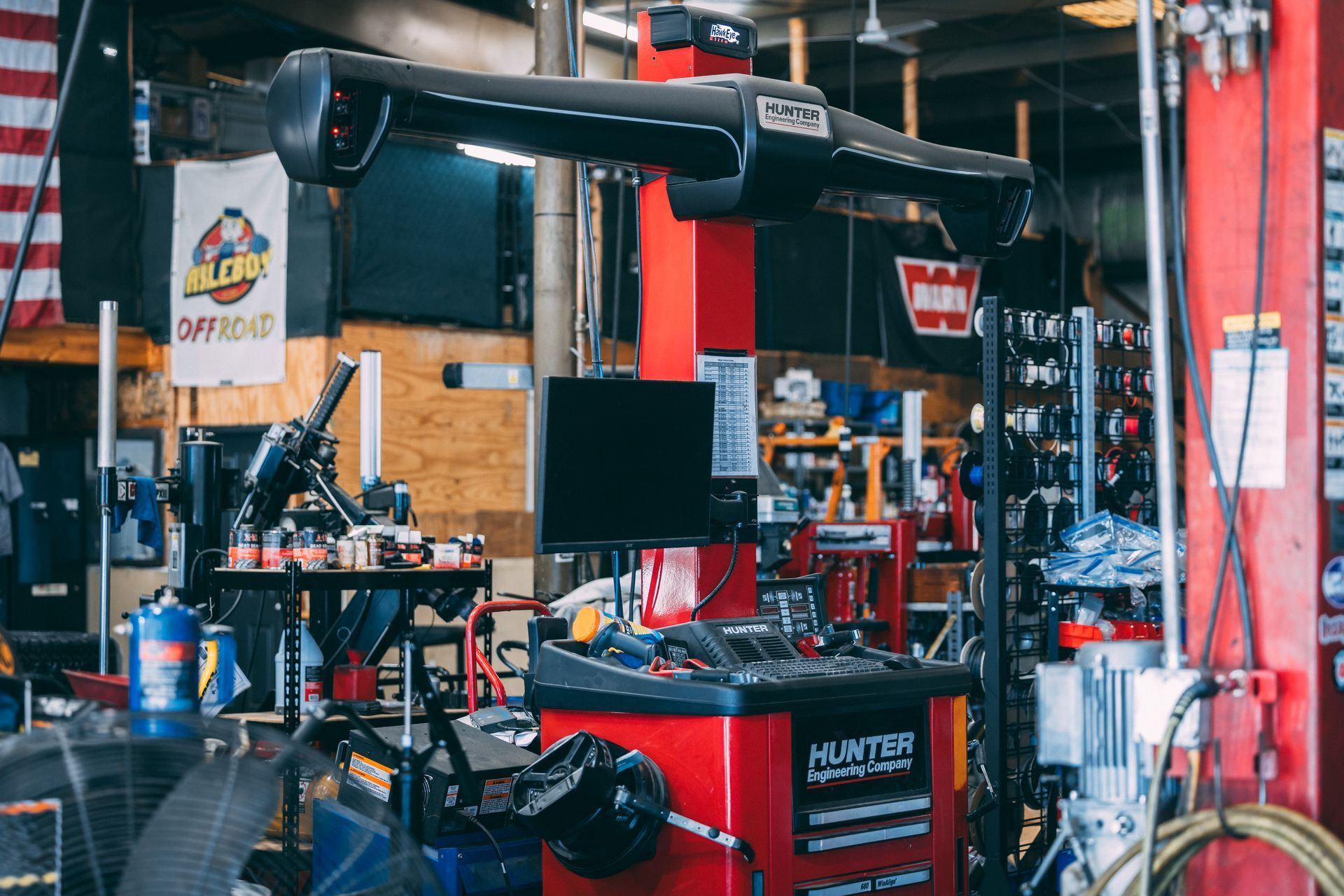 Wheel alignment machine in a car repair shop. Red machine with monitor and tools.