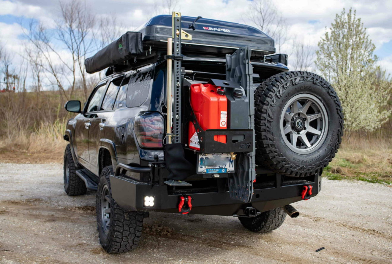 A dark-colored SUV equipped with a rear bumper-mounted storage system featuring a black metal rack.