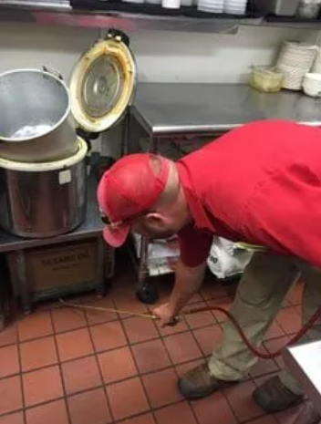 A man in a protective suit is disinfecting a room.
