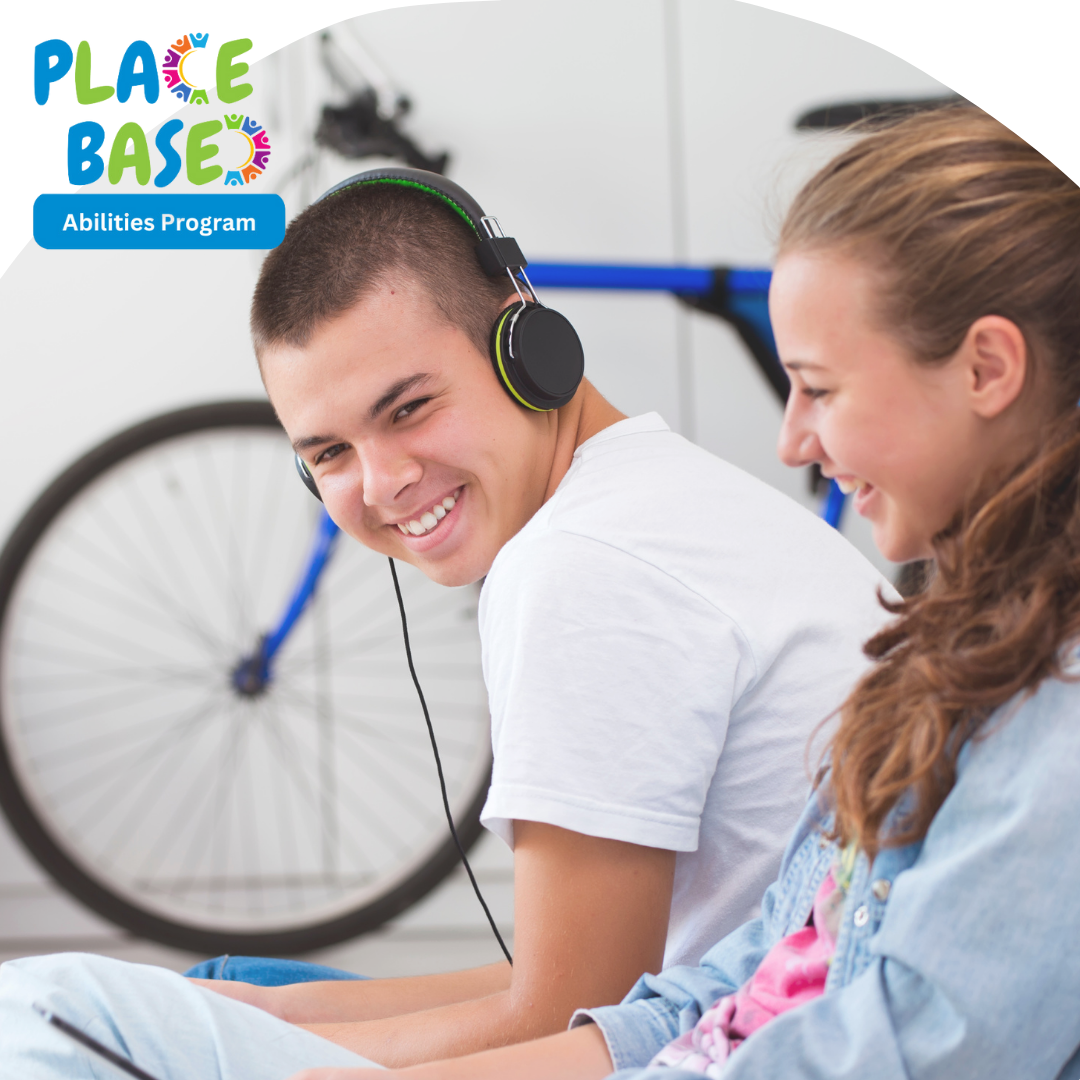 Young person with headphones on sitting next to another young person with long red hair.