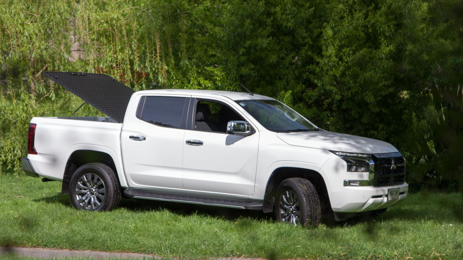 Mitsubishi Triton with MAXIM Hard Lid on the grass.