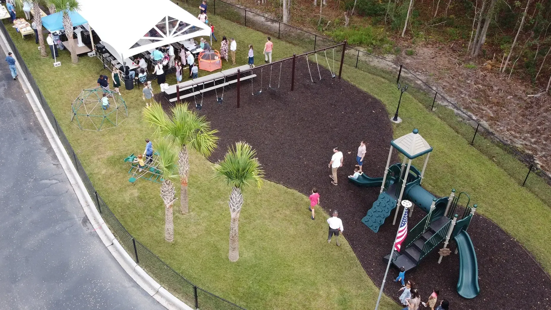 Aerial view of a playground with a tent, people, and equipment.