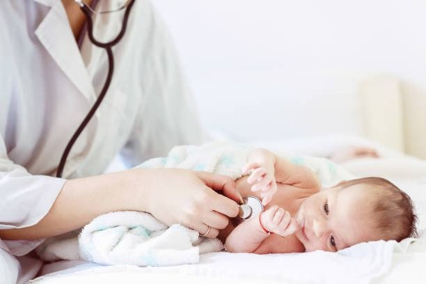 Un médico está examinando a un bebé con un estetoscopio.
