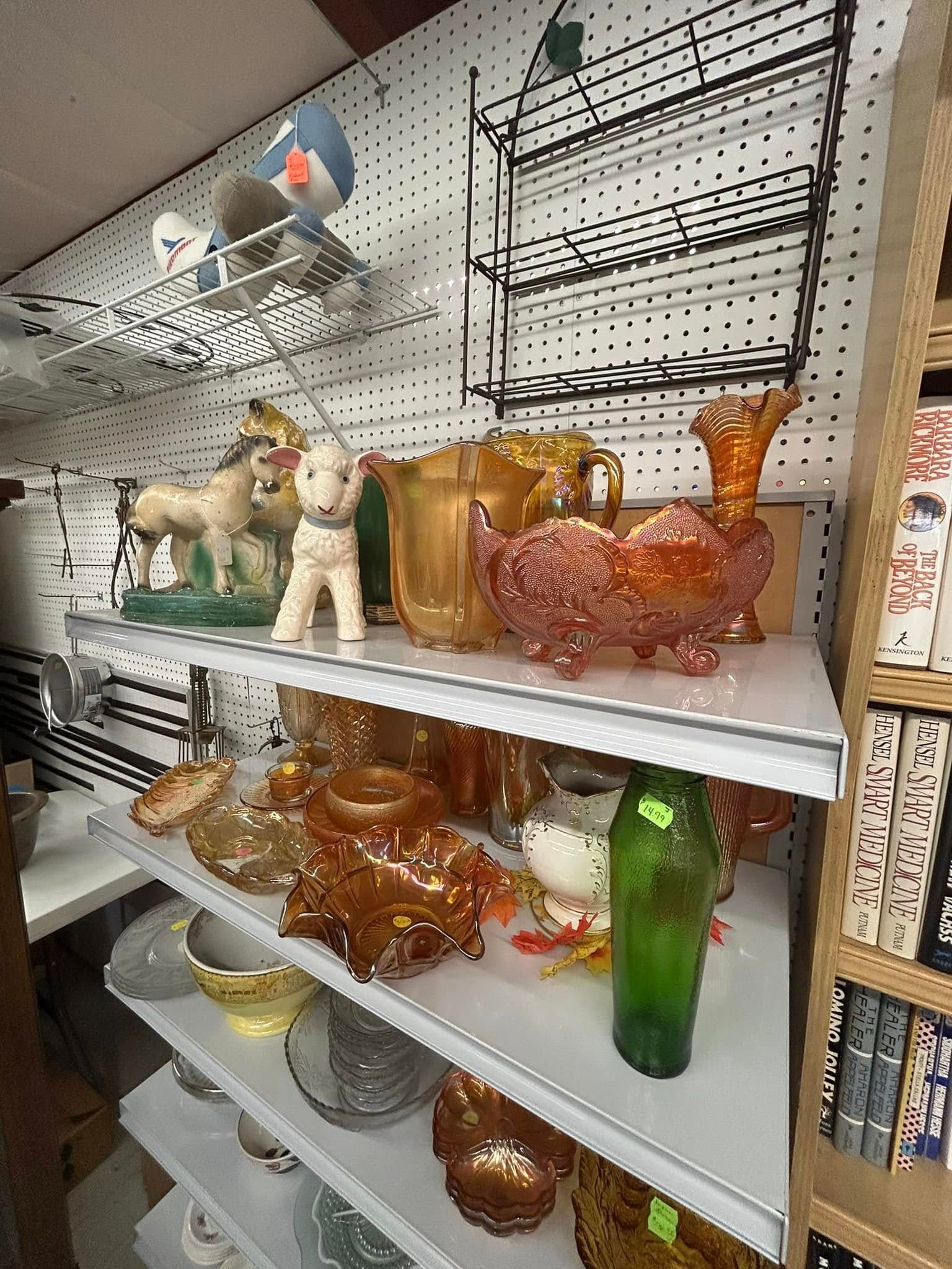 Shelves of colorful glass animal figurines in a store display, including deer, cats, and birds.