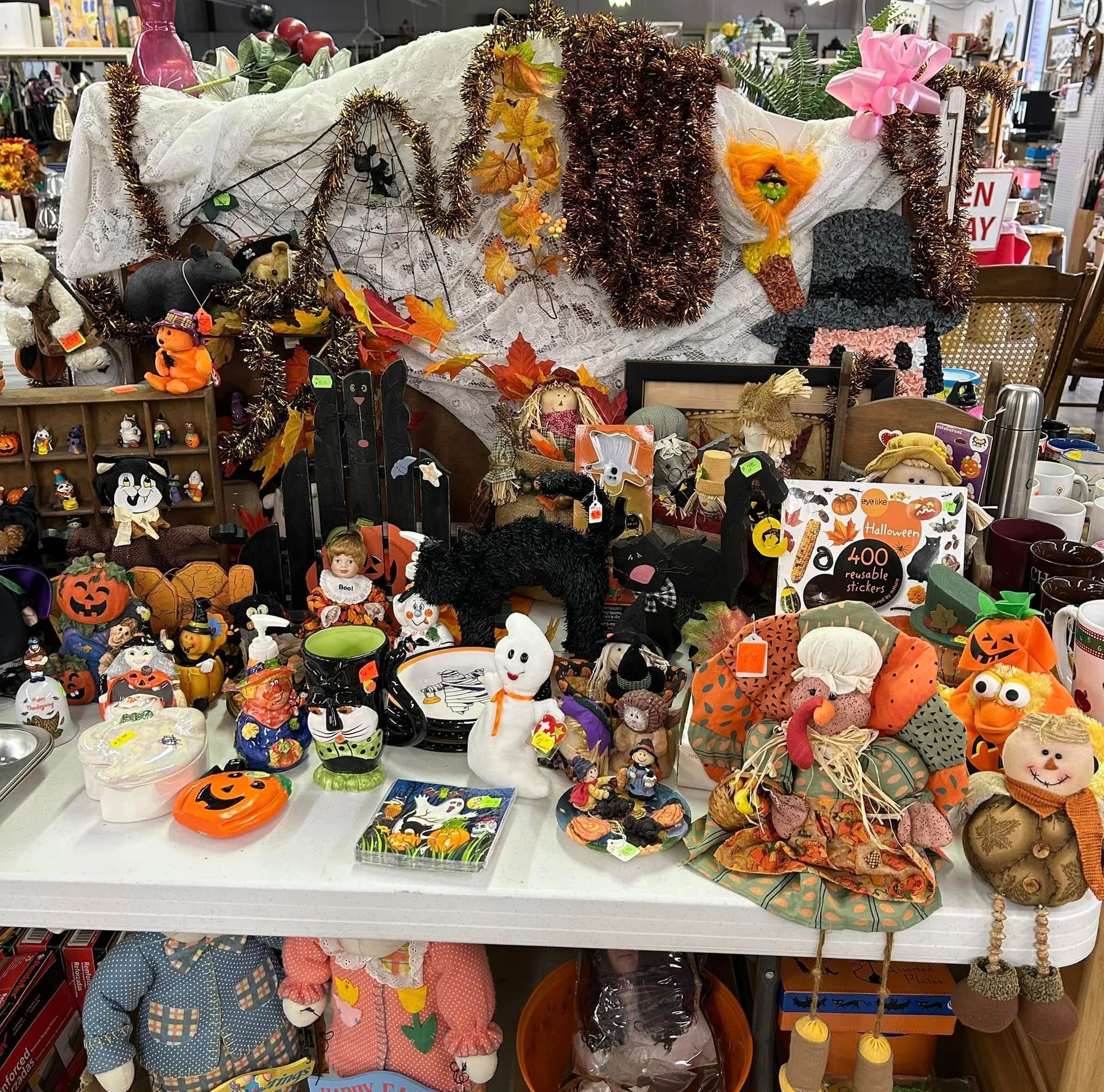 Halloween craft display with spooky plush pumpkins, bats, ghosts, and orange-and-black decorations on a table