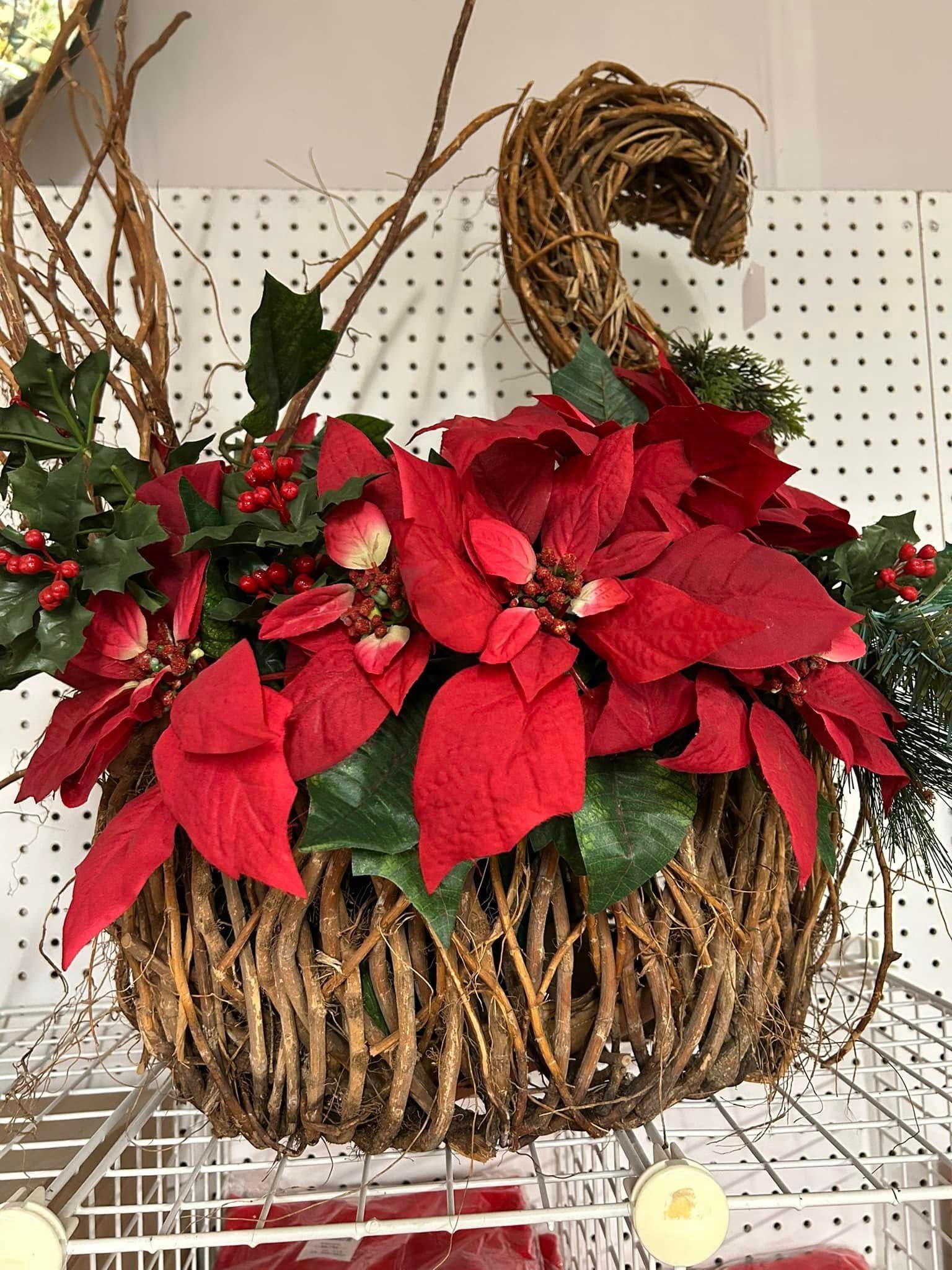 Red poinsettia floral arrangement in a woven basket on a store shelf