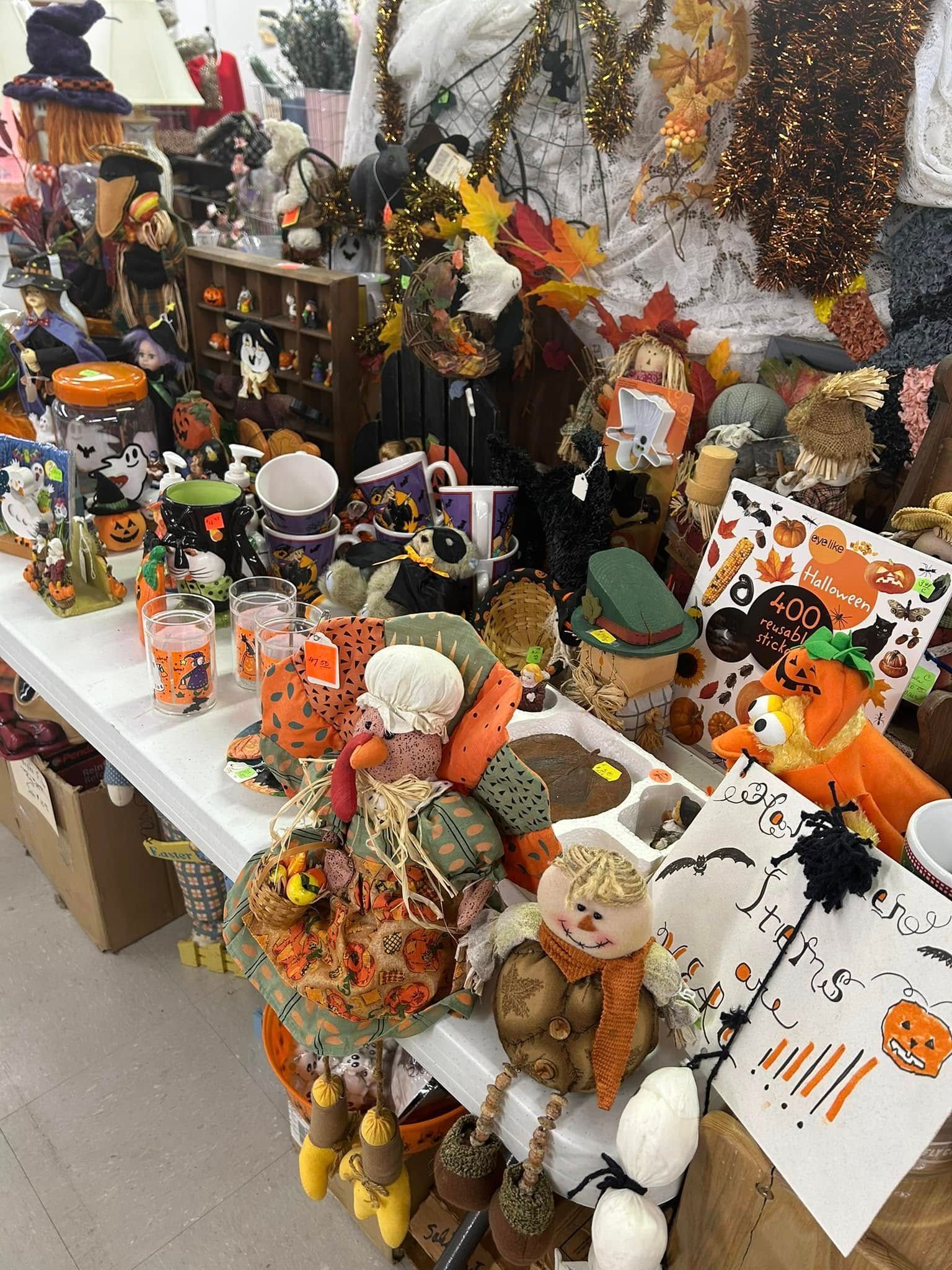 Halloween craft display with pumpkins, ghosts, and colorful handmade dolls on a table