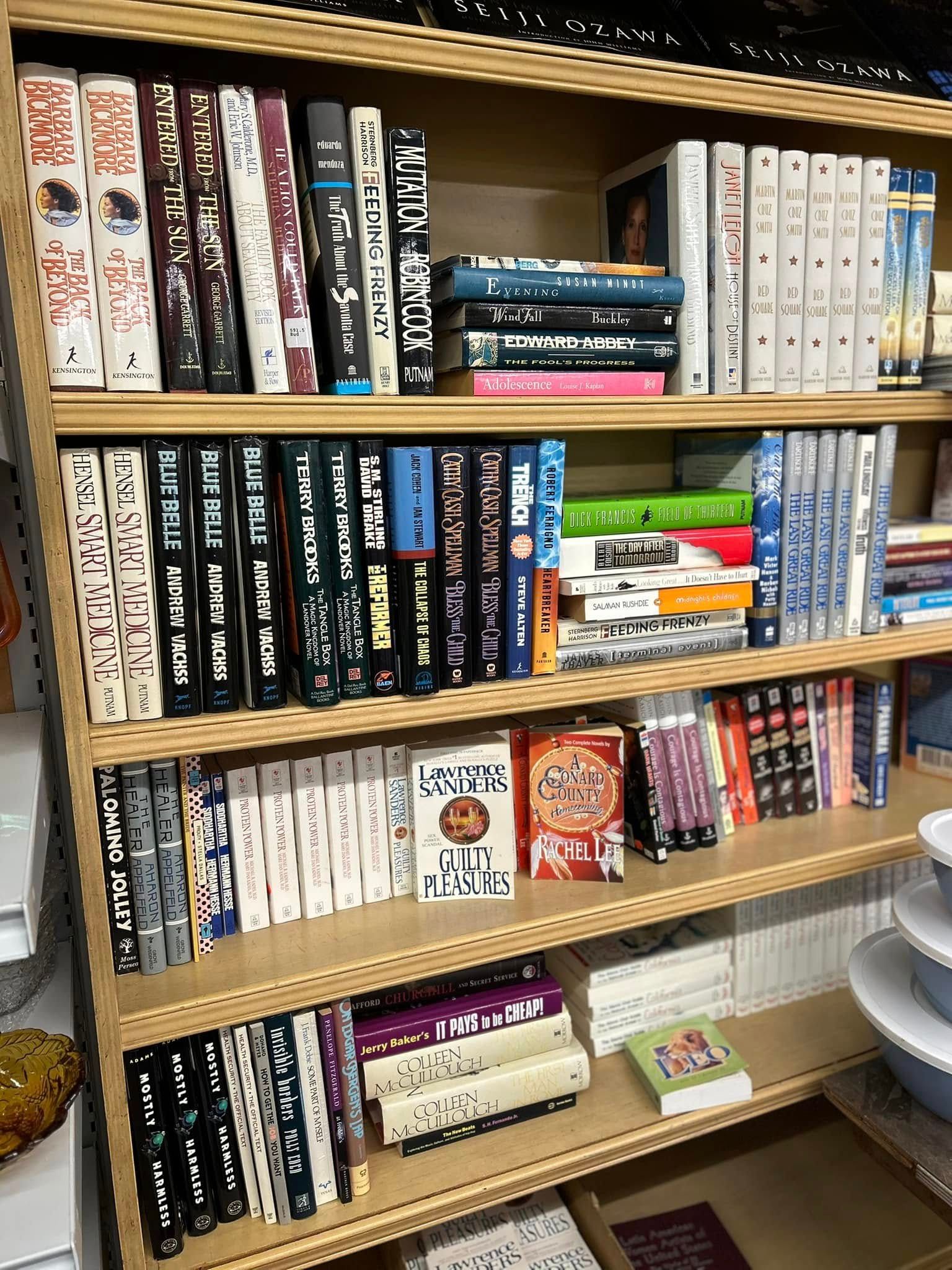 Wooden bookshelf filled with many manga and comic volumes in black, white, and colorful spines