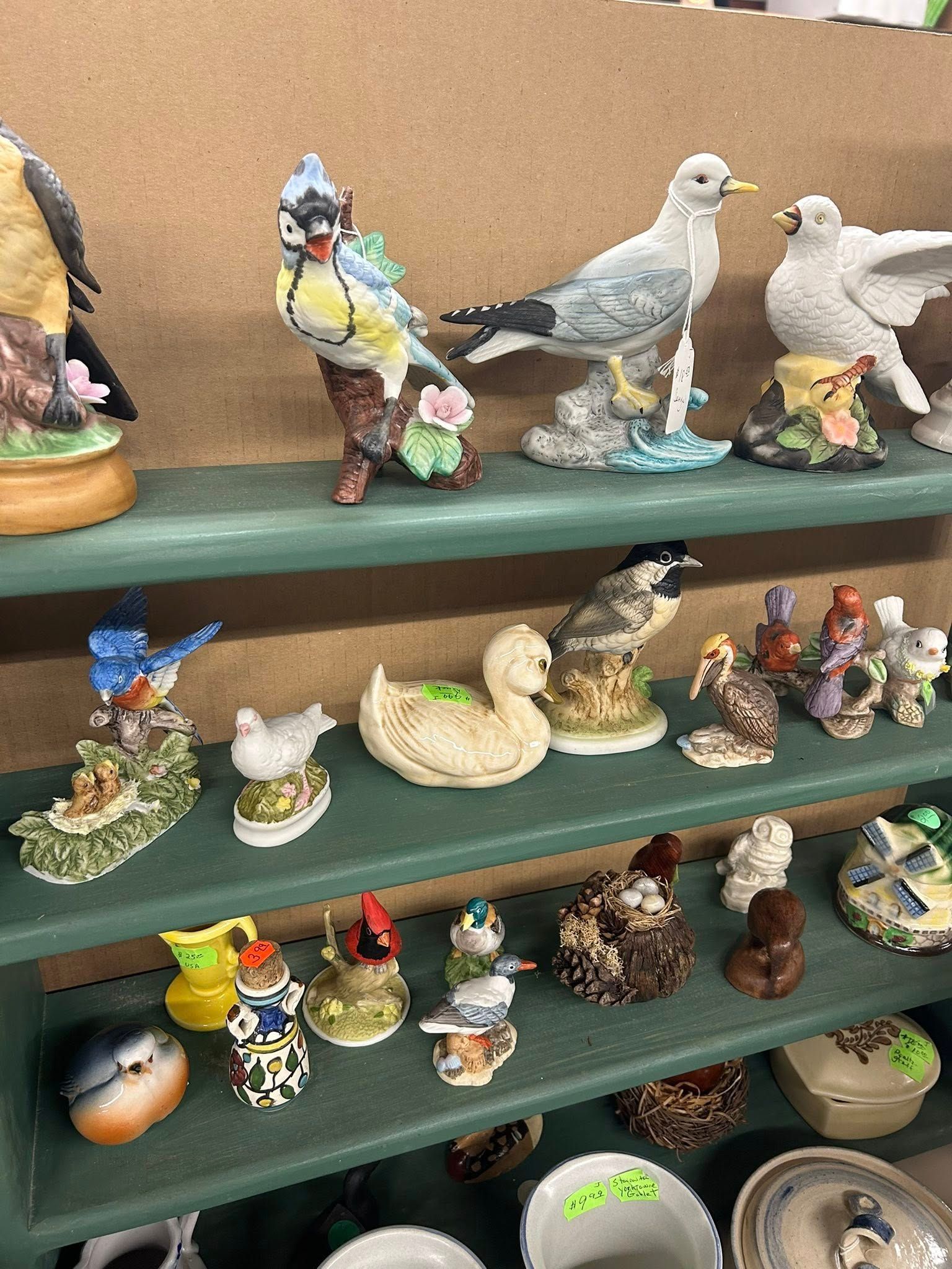Shelves of small bird figurines and animal collectibles in assorted colors and poses