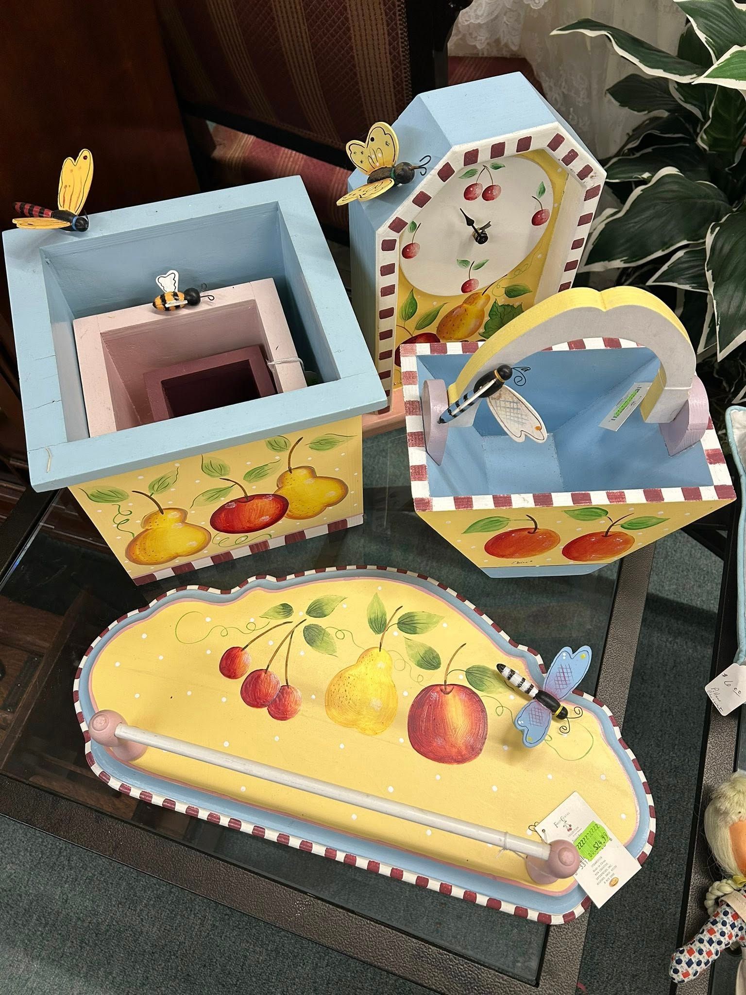 Colorful handmade decorative boxes and a tray with fruit and floral patterns on a table
