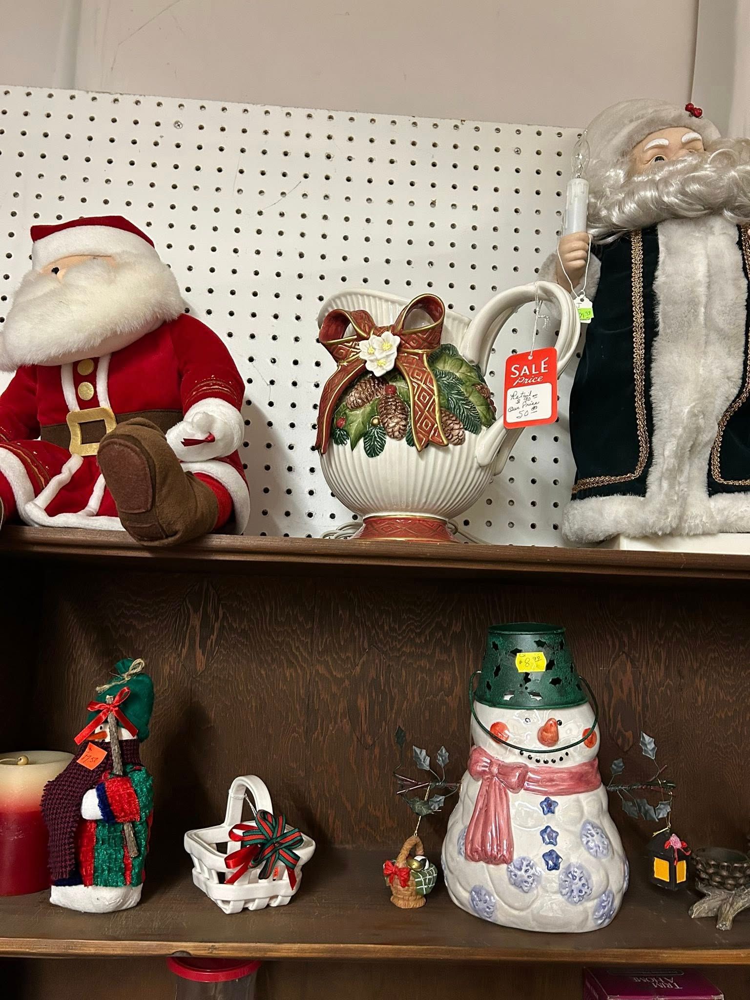 Christmas figurines on store shelves, including Santa, a holiday basket, and a snowman centerpiece.